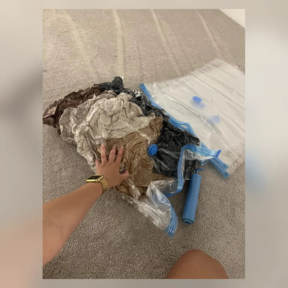 Ropa compactada en bolsas al vacío junto a la bomba manual